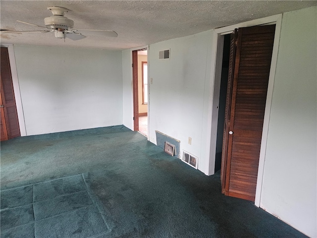 carpeted empty room featuring ceiling fan and a textured ceiling