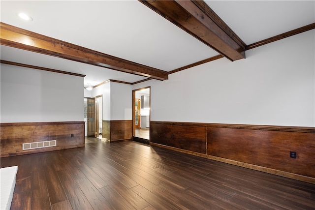 spare room featuring beam ceiling, dark hardwood / wood-style flooring, and ornamental molding