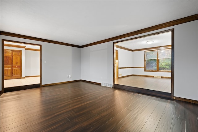 spare room with hardwood / wood-style flooring and crown molding