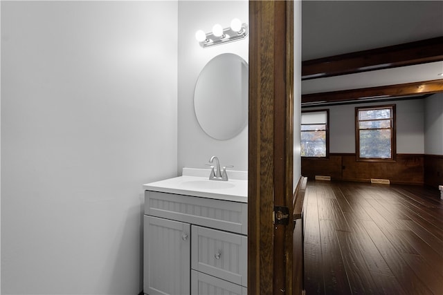 bathroom with wooden walls, vanity, and hardwood / wood-style flooring