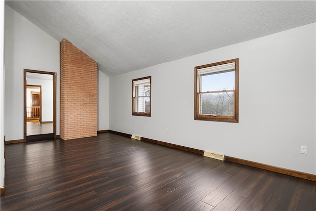 empty room with dark hardwood / wood-style flooring, high vaulted ceiling, and a textured ceiling