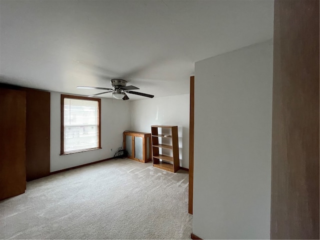 carpeted spare room with ceiling fan