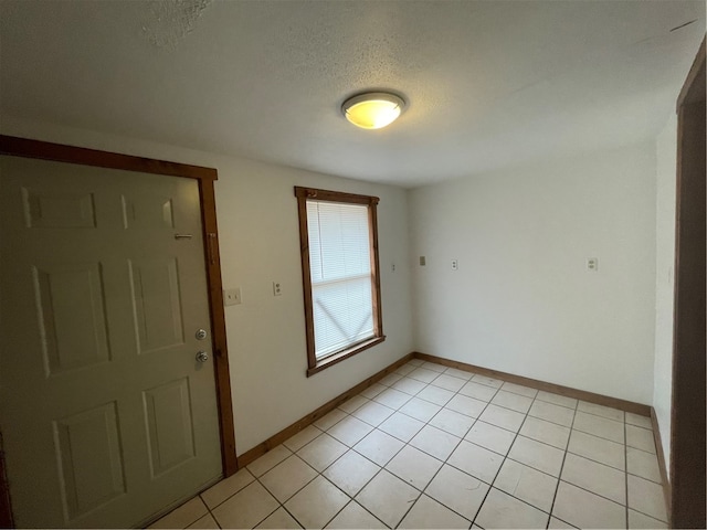 tiled entrance foyer featuring a textured ceiling