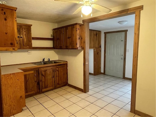 306 E Main St, Ligonier Boro, PA 15658 - kitchen with open shelves, a sink, ceiling fan, light tile patterned floors, and brown cabinets