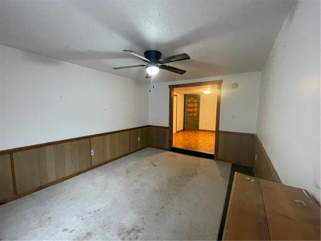 306 E Main St, Ligonier Boro, PA 15658 - unfurnished room with ceiling fan, a wainscoted wall, wood walls, and carpet flooring