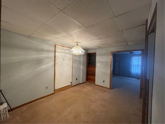 carpeted spare room with a drop ceiling