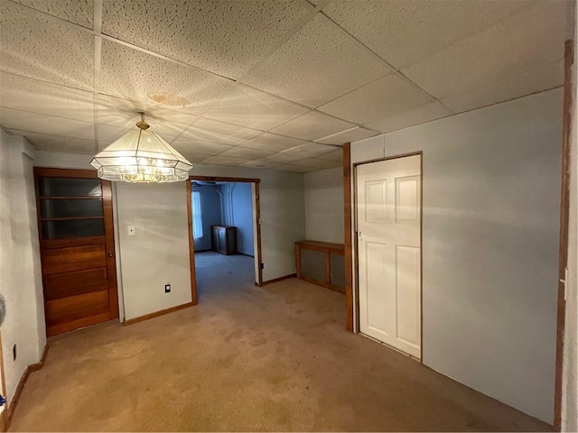 unfurnished dining area featuring carpet flooring and a drop ceiling