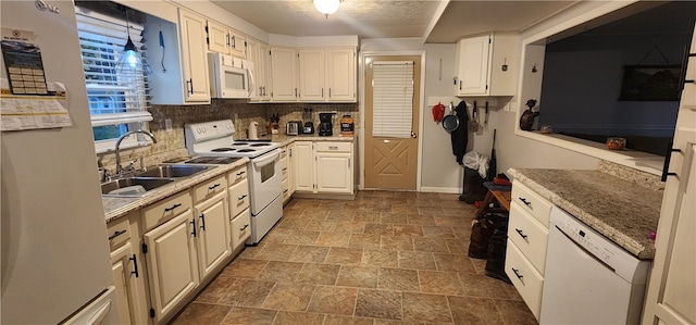 kitchen with decorative backsplash, white appliances, white cabinets, and sink