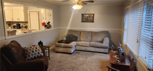 carpeted living room featuring ceiling fan and crown molding