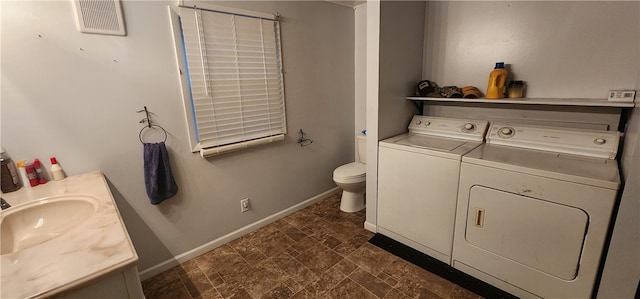 bathroom featuring washer and dryer, vanity, and toilet