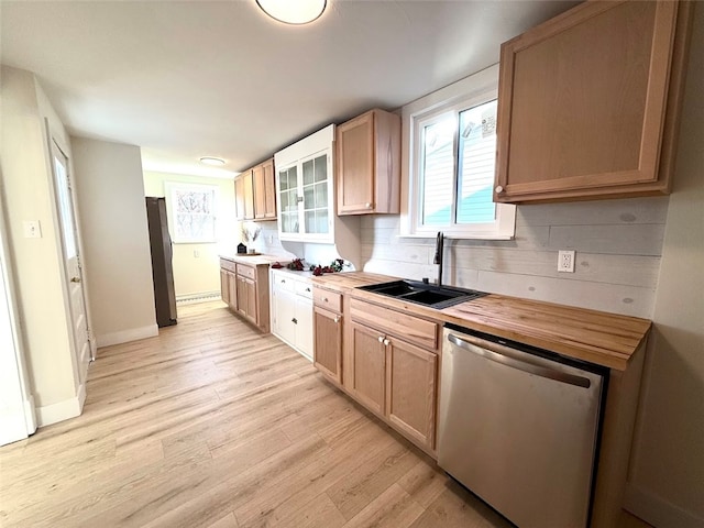 kitchen with appliances with stainless steel finishes, light wood-type flooring, tasteful backsplash, sink, and butcher block countertops