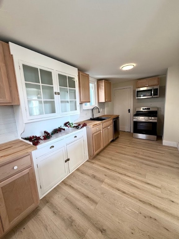 kitchen with light hardwood / wood-style floors, sink, and appliances with stainless steel finishes