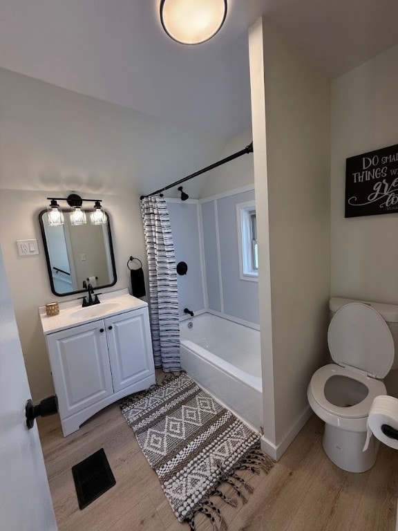 full bathroom featuring vanity, hardwood / wood-style floors, shower / bathtub combination with curtain, and toilet