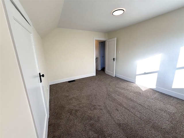 unfurnished bedroom with carpet floors and vaulted ceiling