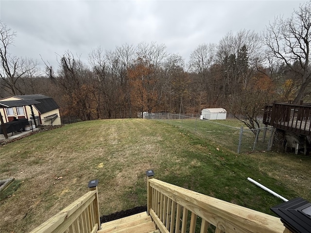 view of yard with a deck and a storage shed