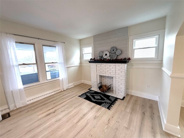 living room featuring a fireplace, light hardwood / wood-style flooring, and baseboard heating