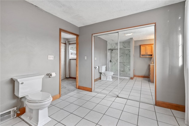 bathroom with tile patterned floors, toilet, and a textured ceiling