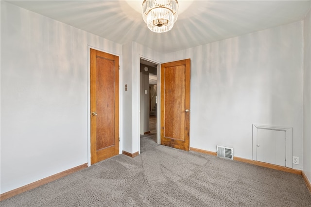 unfurnished room with carpet flooring and an inviting chandelier