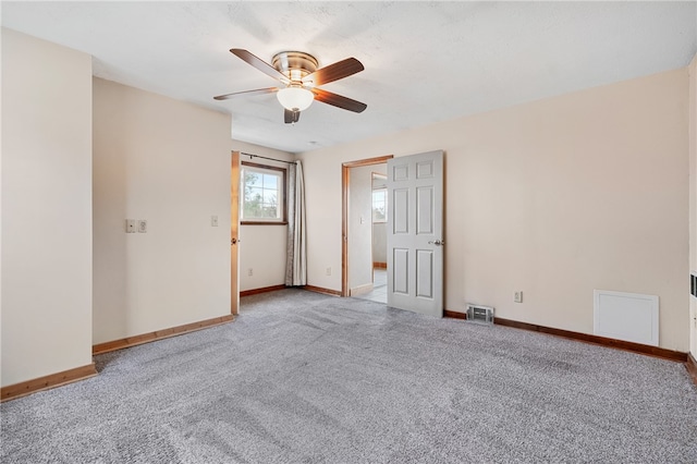 empty room featuring ceiling fan and light carpet