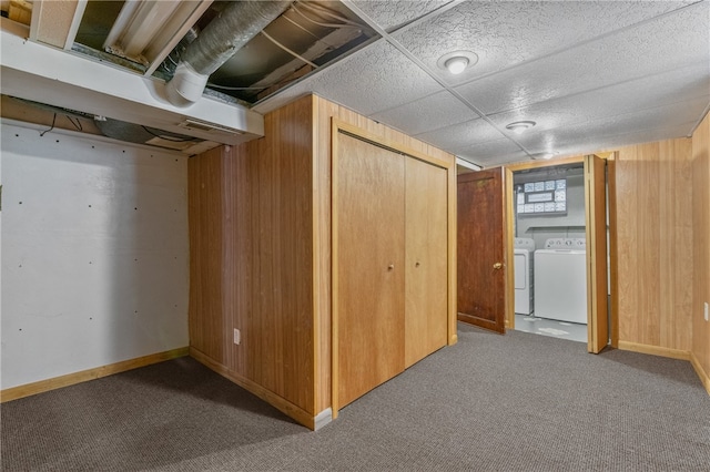 basement featuring carpet, independent washer and dryer, and wooden walls