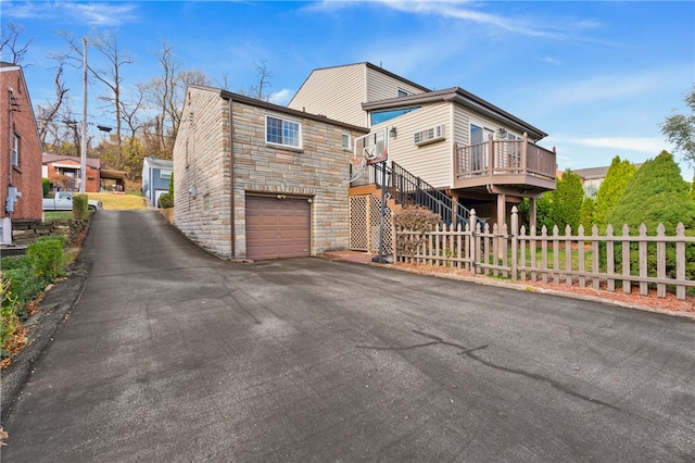 view of side of property featuring a wooden deck and a garage