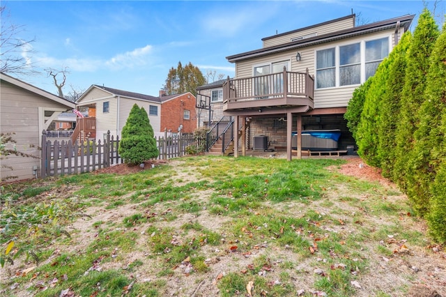 back of property with a wooden deck, cooling unit, and a hot tub