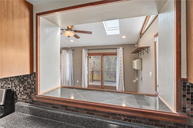 interior space featuring ceiling fan and a skylight