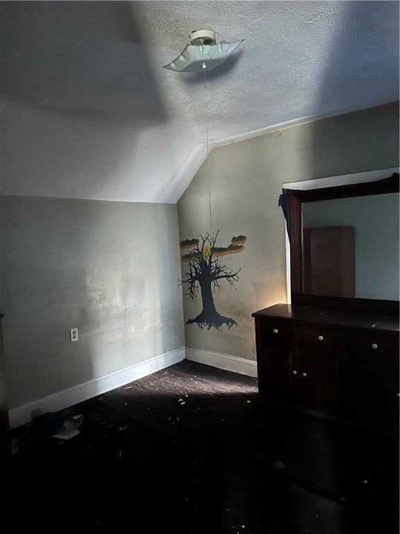 bonus room with a textured ceiling and vaulted ceiling