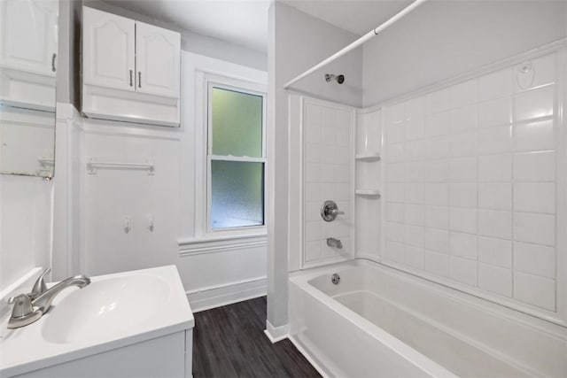 bathroom featuring a wealth of natural light, vanity, tiled shower / bath combo, and hardwood / wood-style flooring