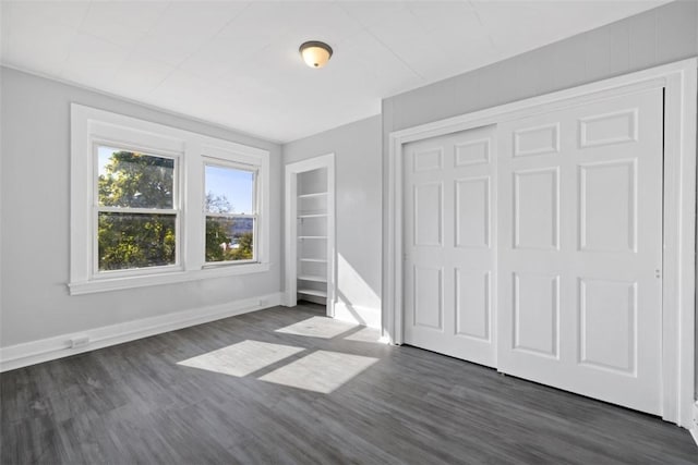 unfurnished bedroom featuring dark hardwood / wood-style flooring and a closet