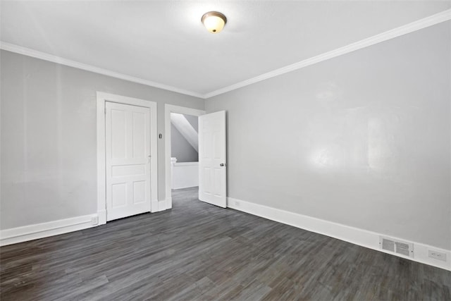 spare room featuring ornamental molding and dark wood-type flooring