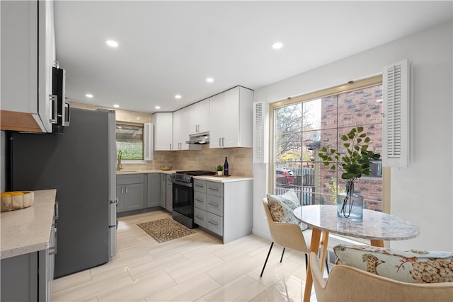 kitchen featuring gray cabinetry, a healthy amount of sunlight, sink, and black range with gas cooktop