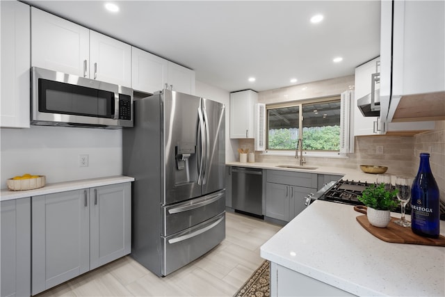 kitchen with white cabinets, appliances with stainless steel finishes, gray cabinets, and sink