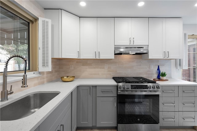 kitchen featuring gray cabinetry, sink, tasteful backsplash, white cabinetry, and stainless steel range with gas stovetop