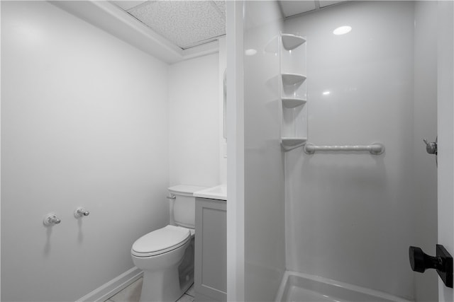 bathroom featuring a paneled ceiling, tile patterned flooring, vanity, and toilet