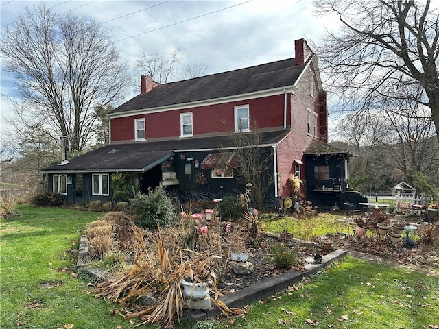 back of property featuring a yard