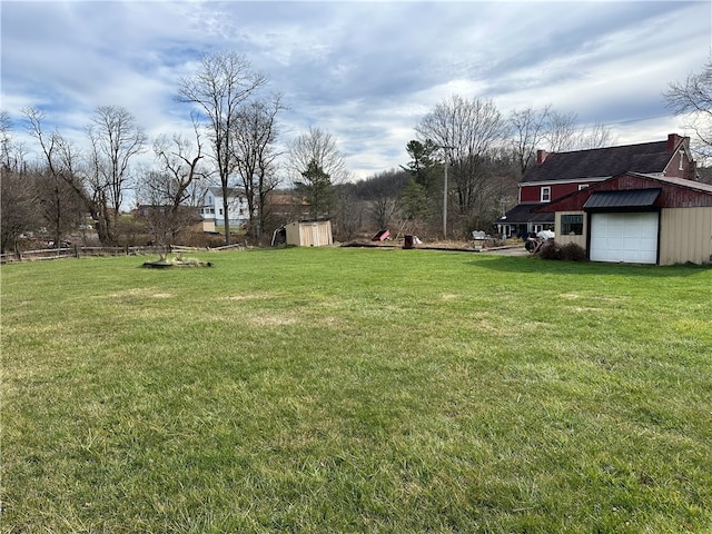 view of yard featuring a garage and a storage shed