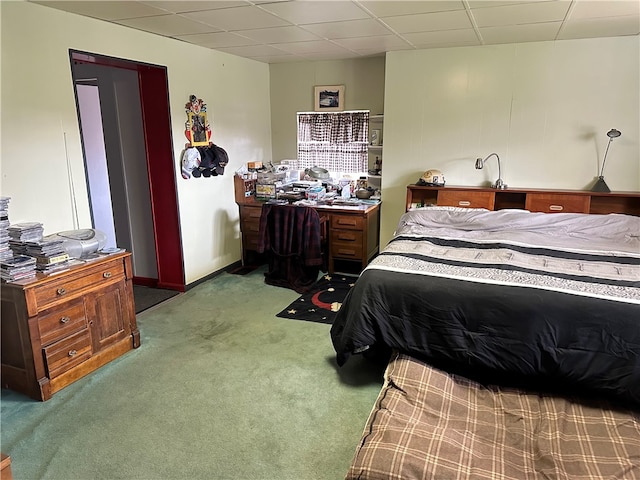 carpeted bedroom featuring a drop ceiling