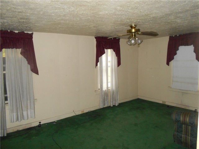 carpeted spare room featuring ceiling fan and a textured ceiling