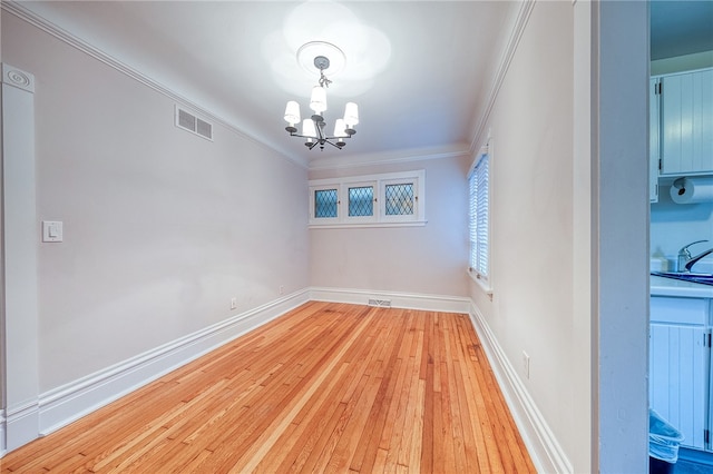 spare room with a chandelier, crown molding, sink, and light hardwood / wood-style floors