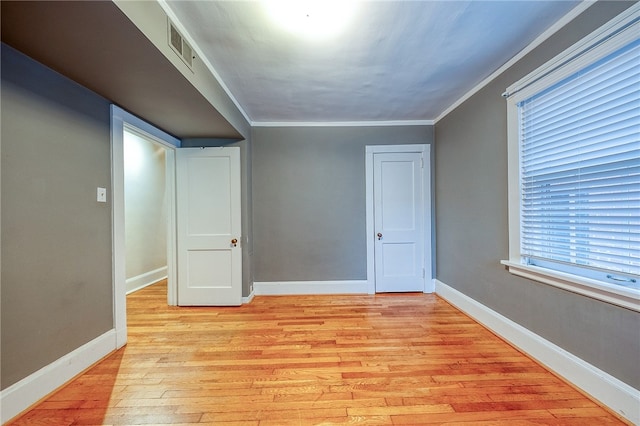 interior space with crown molding and light hardwood / wood-style flooring