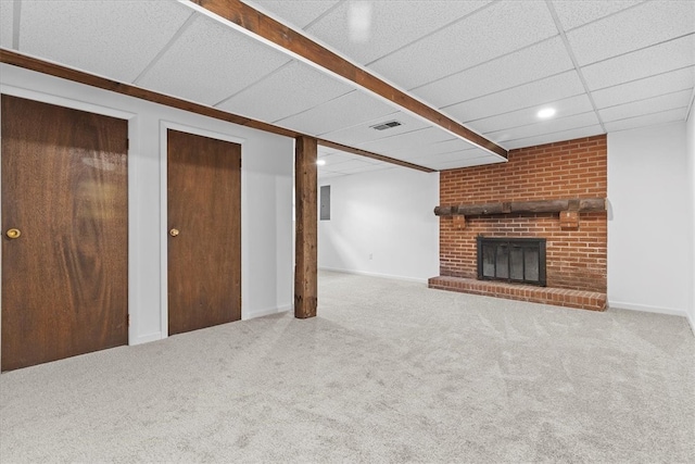 unfurnished living room with carpet, a paneled ceiling, and a fireplace