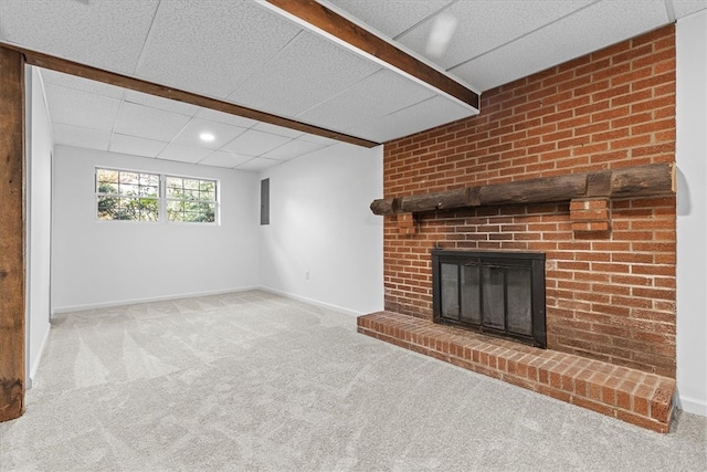 unfurnished living room featuring a paneled ceiling, a fireplace, and carpet