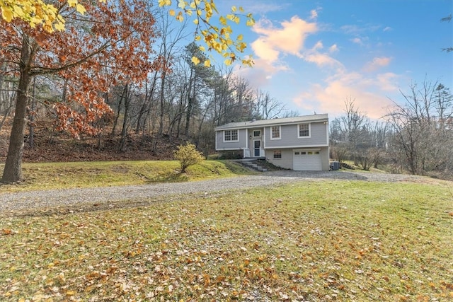 bi-level home featuring a garage and a lawn