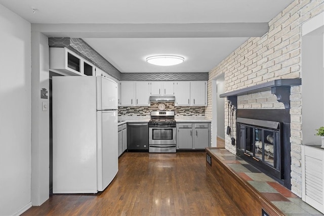 kitchen with dark hardwood / wood-style flooring, decorative backsplash, a fireplace, white cabinets, and appliances with stainless steel finishes