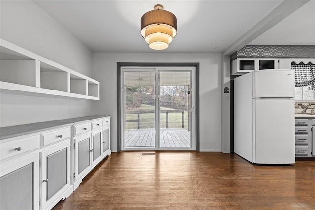 kitchen with dark hardwood / wood-style flooring, white cabinets, and white refrigerator