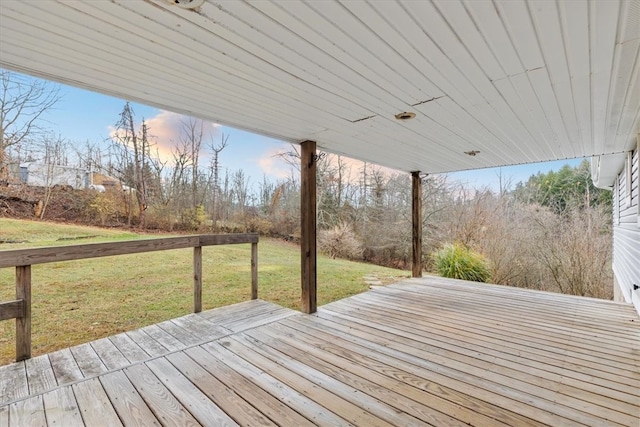 deck at dusk featuring a yard