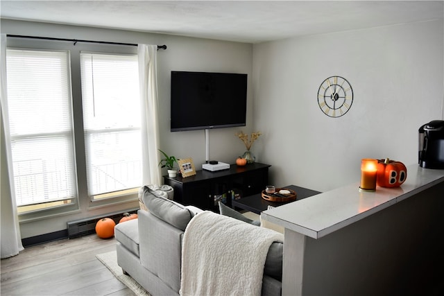 living room with light hardwood / wood-style floors and a baseboard heating unit