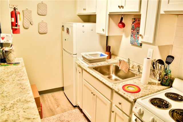 kitchen with light stone countertops, sink, pendant lighting, white appliances, and light wood-type flooring