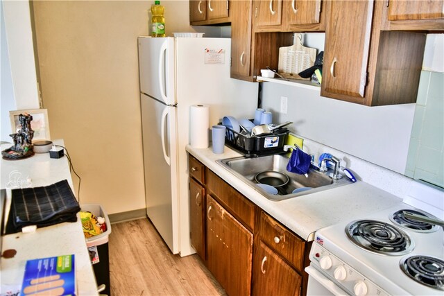 kitchen featuring light hardwood / wood-style floors, white appliances, and sink